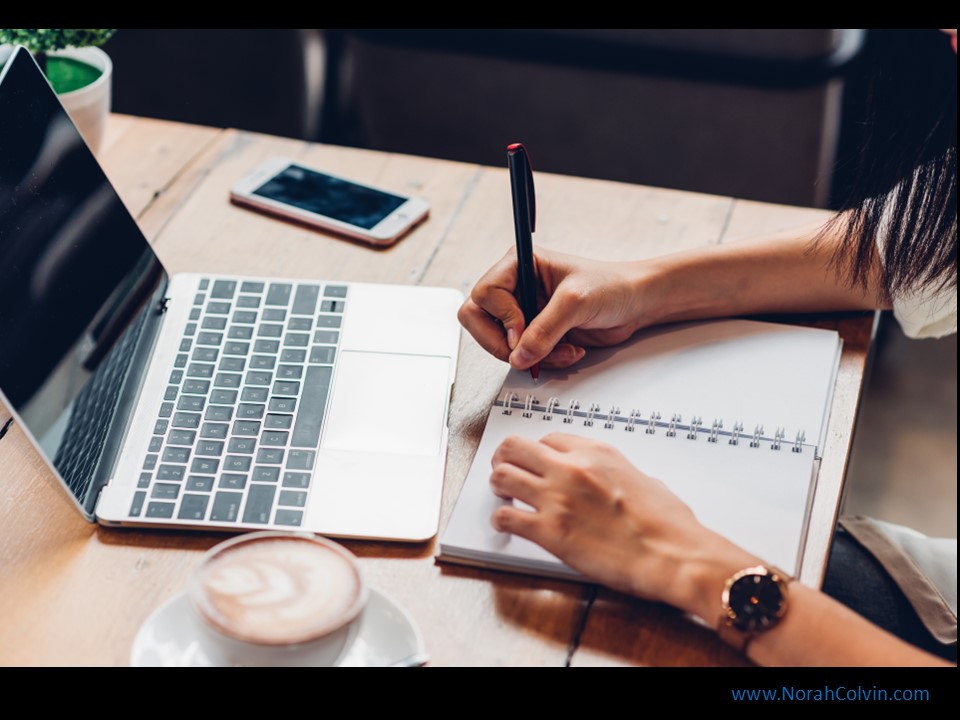 a laptop, a notebook, someone writing